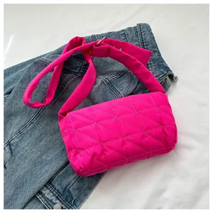 Close-up of pink quilted crossbody bag made of Oxford cloth on a denim jacket