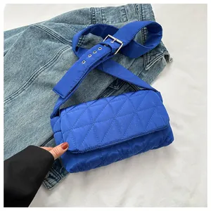 Close-up of Klein blue quilted puffer bag with adjustable wide strap and silver buckle