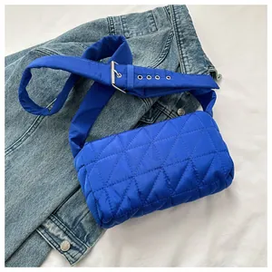 Close-up of klein blue quilted nylon crossbody bag with adjustable wide strap and eyelets