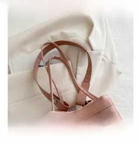 Détails du sac seau rose avec texture mate, coutures et rivets métalliques élégants