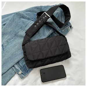 Detail of black quilted oxford cloth crossbody bag with wide adjustable silver buckle strap