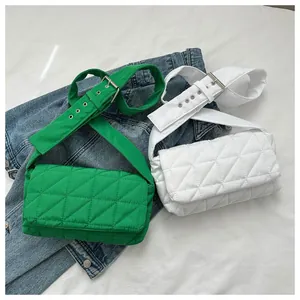 Detail of green and white quilted crossbody bags with wide adjustable shoulder straps