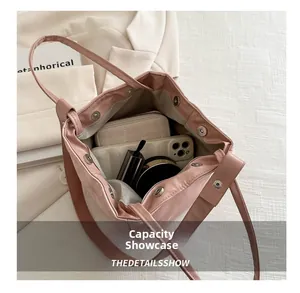 Sac seau rose à cordon vue intérieure montrant téléphone, portefeuille et rouge à lèvres