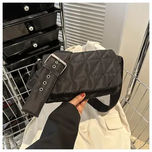 Close-up of black quilted nylon crossbody bag with wide metal eyelet strap in metal cart