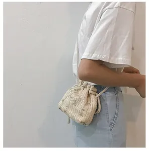 Détail d'un sac seau tissé avec broderie florale verte et cordon de serrage pratique