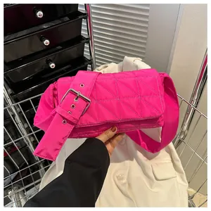 Detail of fuchsia quilted crossbody bag with wide adjustable strap and metal buckle