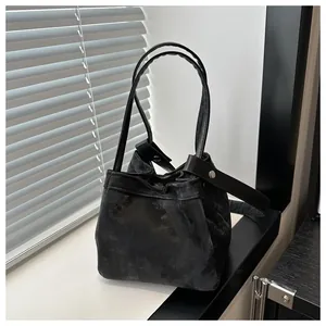 Détail du sac seau noir avec texture délavée et boutons-pression en métal argenté