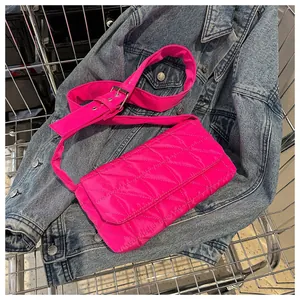 Macro detail of rose pink quilted crossbody bag featuring stitching and wide strap