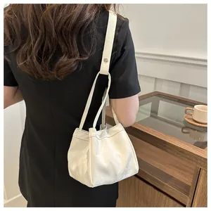 Sac seau crème chic présenté dans un cadre de vie avec une lumière douce et une tasse