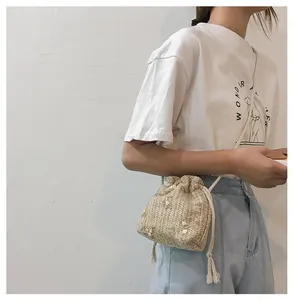 Détail de broderie florale et texture tissée sur un sac seau à cordon coulissant