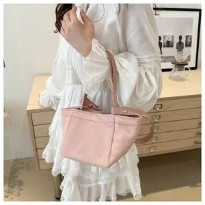Détail du sac seau rose clair avec cuir PU plissé doux et rivets métalliques