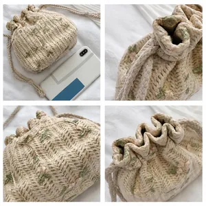Detail der gewebten Stroh-Beuteltasche mit Blumenstickerei und Kordelzugverschluss