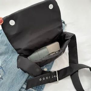Black quilted crossbody bag showing interior capacity for smartphone and wallet items