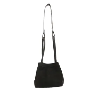 Sac seau minimaliste en daim noir avec poignée supérieure et fine bandoulière réglable