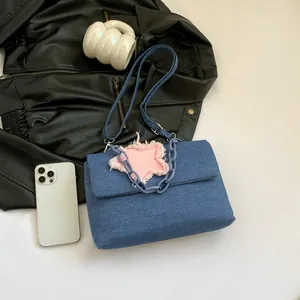 Blue denim shoulder bag with pink star patch and chunky chain strap for women