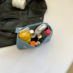 Light blue denim shoulder bag showing large capacity with umbrella and daily essentials