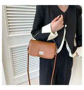 Détail d'un sac à bandoulière caramel avec fermoir rotatif argenté en forme de cœur