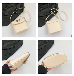 Dettagli di una borsa a tracolla beige con fiocco in metallo argento e tracolla regolabile