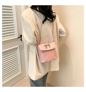 Vista posteriore della borsa rosa con fibbia a fiocco argento su blazer e jeans