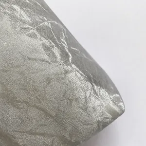 Macro del tessuto argentato di una borsa di perle con dettagli a trama metallica stropicciata