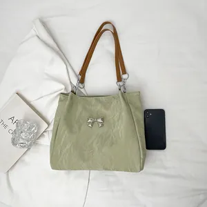 Light green pleated tote bag with silver butterfly buckle and brown leather strap