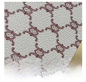 Close-up of white lychee texture leather with vintage monogram patterns and gold hardware