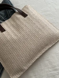 Detailed close-up of woven herringbone pattern and premium brown leather handle