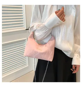 Dettaglio della borsa rosa con perline con manico di perle e scritte moda in oro