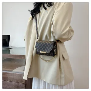 Detail view of retro brown geometric pattern crossbody bag with golden chain accent