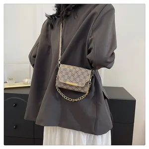 Retro plaid square bag with gold chain and crossbody strap worn on a gray blazer