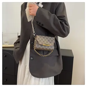 Macro view of vintage chain-link pattern and golden metal clasp on small crossbody bag