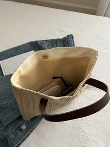 Interior detail of straw tote bag showing magnetic clasp, fabric lining, and large capacity