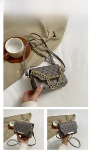 Detailed view of grey printed crossbody bag with gold chain and metal bar closure
