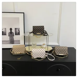 Detail of vintage patterned crossbody bags with gold chains in various stylish colors