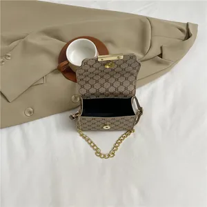 Retro vintage patterned crossbody bag with gold chain strap on stylish beige blazer