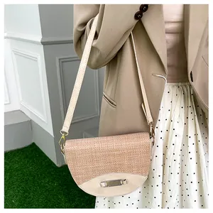 Detail of light beige saddle bag featuring woven texture and smooth leather finish