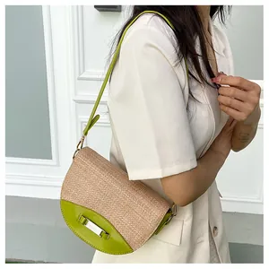 Detail of contrast woven saddle bag with bright green leather flap and metal buckle
