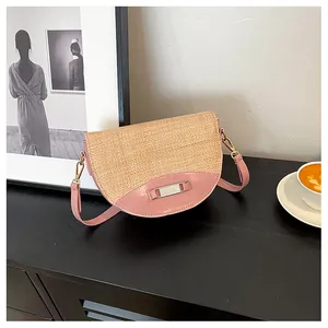 Detail of woven straw saddle bag with pink leather trim in a chic cafe setting