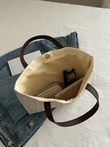 Top view of woven straw bucket bag interior with magnetic clasp and daily essentials