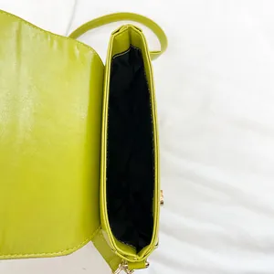 Lime green woven saddle bag with gold metal hardware and smooth PU leather finish