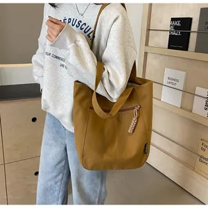 Close-up of yellow canvas tote bag with woven rope zipper detail and fashion side label