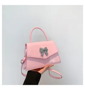Detail of pink patent leather handbag with silver metallic butterfly buckle and strap