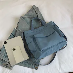 Blue canvas large tote bag with adjustable strap and multiple pockets for daily commuting
