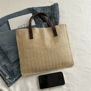 Fashionable straw tote bag with brown leather handles and woven chevron pattern for beach