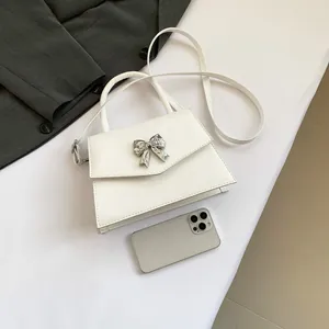 Minimalist white trapezoid handbag with silver butterfly buckle and slim shoulder strap