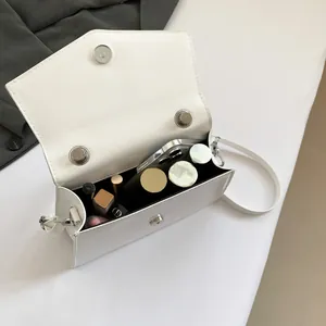 Minimalist white leather crossbody bag with silver magnetic flap and interior capacity view