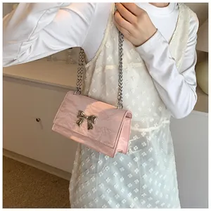 Détail du sac rose à motif marbré avec nœud argenté et double bandoulière chaîne