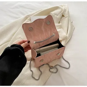 Detail of pink marble textured chain bag showing magnetic closure and interior space