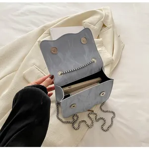 Close-up of light blue wave edge bag showing marble texture and silver magnetic buckles