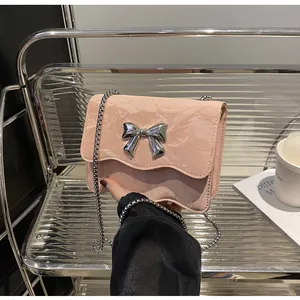 Close-up of pink bow chain bag with marble texture and silver metallic bow clasp
